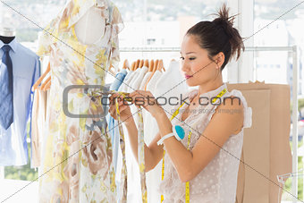 Beautiful female fashion designer working on dress