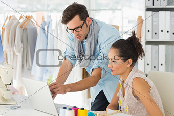 Fashion designers using laptop in studio