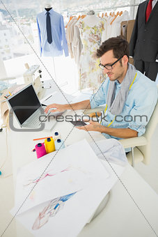 Fashion designer using laptop and cellphone