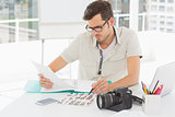 Concentrate male artist sitting at desk with photos