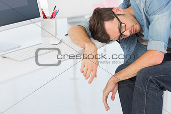 Young casual man sleeping in front of computer