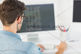 Casual male photo editor using computer