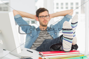 Relaxed casual young man with legs on desk