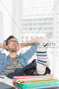 Casual man with legs on desk in office