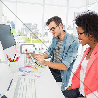 Casual young couple working on computer in office