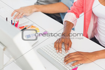 Mid section of a casual couple working on computers