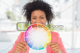Beautiful young woman holding color wheel