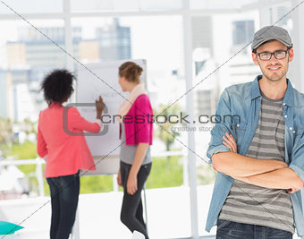Casual male artist with colleagues in background at office