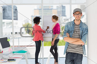 Casual male artist with colleagues in background at office