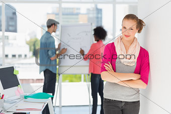 Casual artist with colleagues in background at office