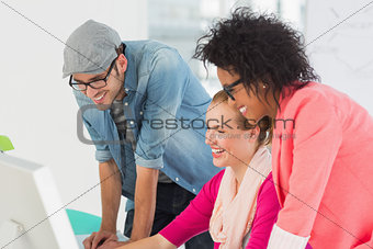 Smiling artists working on computer at office