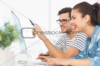 Happy young couple working on computer in an office