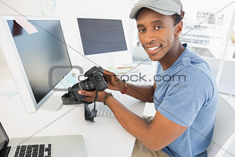Male photo editor with digital camera in office
