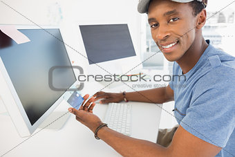 Casual young man doing online shopping in office