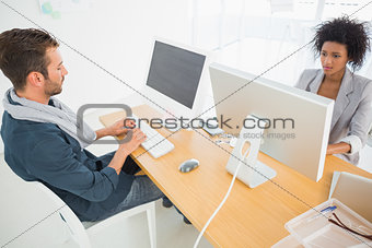 Young man and woman working on computers