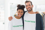 Portrait of two young volunteers with arms around