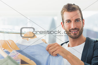 Handsome male customer by clothes rack