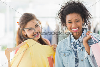 Portrait of two happy young women with shopping bags