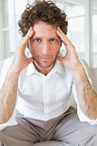 Worried well dressed man sitting with head in hands