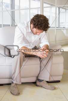 Well dressed man sitting with head down at home
