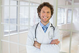 Handsome male doctor standing with arms crossed
