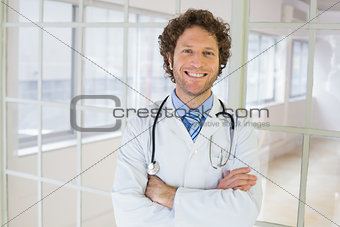 Handsome male doctor standing with arms crossed