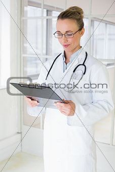 Beautiful female doctor with clipboard in hospital