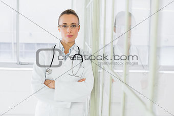 Serious female doctor with arms crossed in hospital