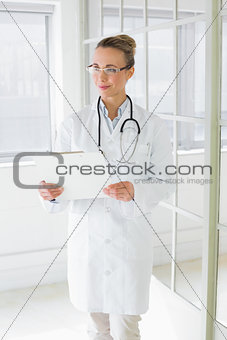 Beautiful female doctor with clipboard in hospital