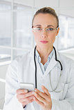 Portrait of a female doctor reading text message