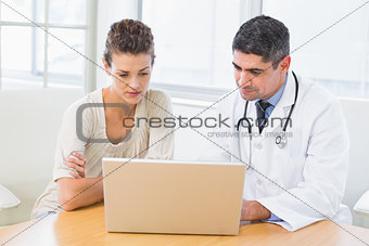 Doctor and patient using laptop in medical office