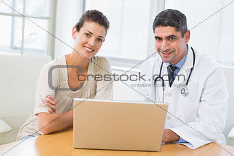 Doctor and patient using laptop in medical office