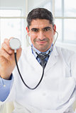 Confidence male doctor holding stethoscope