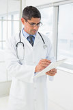 Concentrated male doctor writing reports