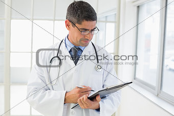 Serious male doctor writing reports