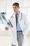 Serious male doctor examining xray