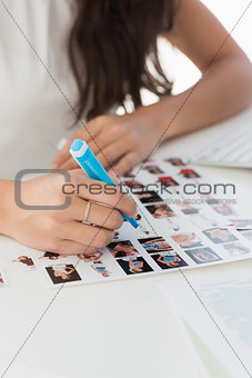 Editor working at desk marking a contact sheet