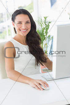Cheerful businesswoman sitting at her desk