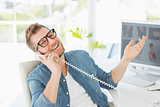 Handsome designer laughing on the telephone looking at camera