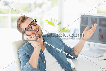 Handsome designer laughing on the telephone looking at camera
