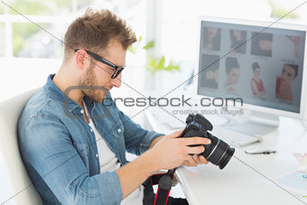 Handsome photographer looking at his camera