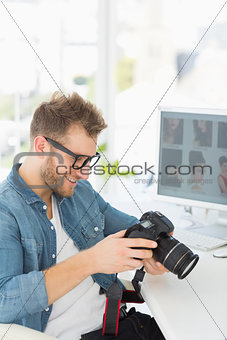 Handsome photographer holding his camera and smiling
