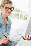 Blonde happy designer using digitizer at her desk