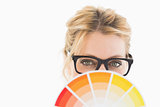 Blonde designer wearing glasses holding colour wheel