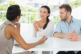 Therapist talking with couple sitting at desk