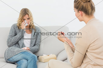 Therapist listening to crying patient on the sofa