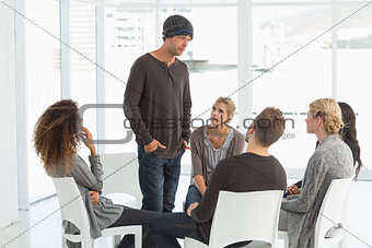 Rehab group listening to man standing up introducing himself