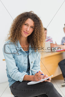 Cheerful designer sitting in front of her colleagues using digital tablet