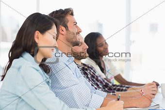 Smiling team of designers listening at meeting
