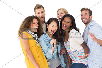 Happy group of young friends having fun doing karaoke